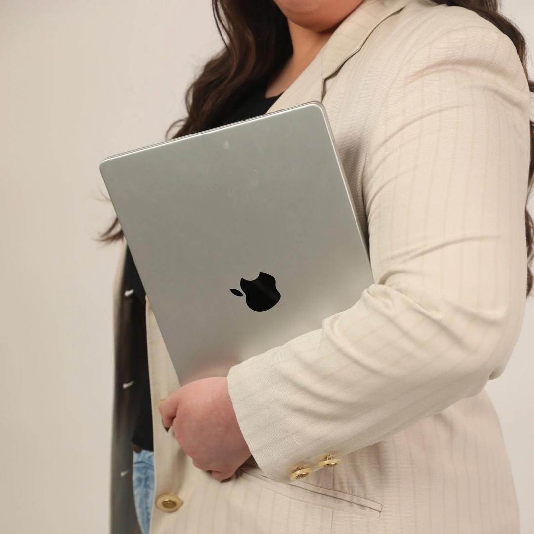 Jenna holding her laptop in the studio